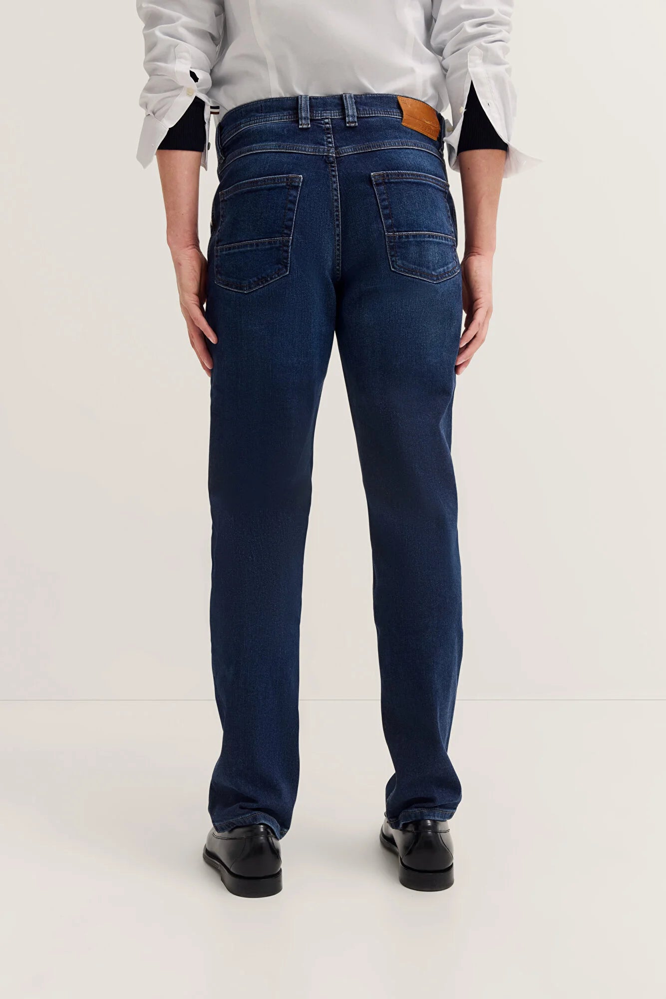 Person wearing blue jeans on a white background