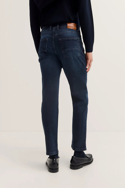 Person wearing dark blue jeans on a white background