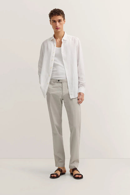 Man wearing a white shirt, light gray pants, and sandals on a white background