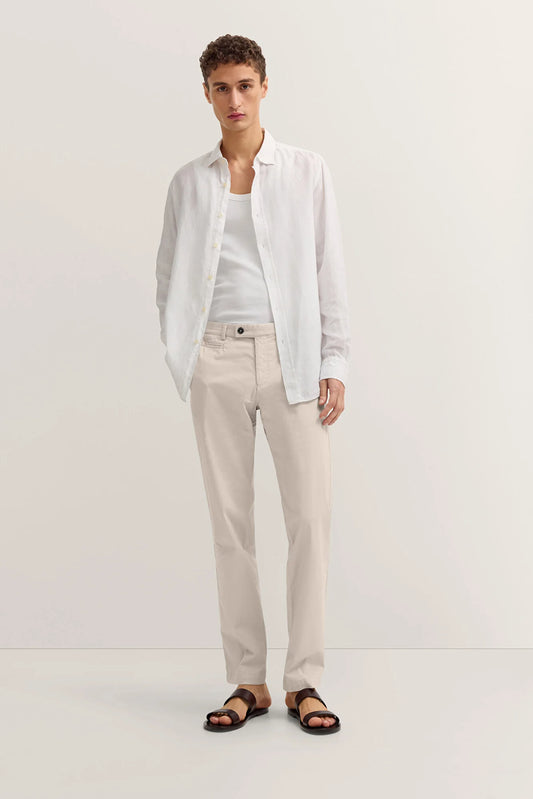 Person wearing a white shirt, beige pants, and sandals on a white background
