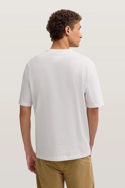 Person wearing a plain white t-shirt on a light background