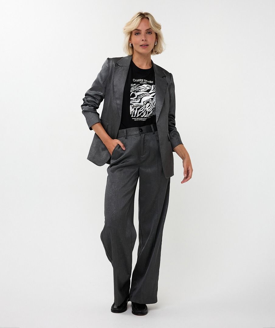 Person wearing a gray suit with a black graphic t-shirt on a white background